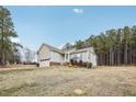 View of the home's exterior, showcasing the backyard and trees at 165 Turlington Rd, Dunn, NC 28334