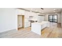 Modern white kitchen with island, stainless steel appliances, and hardwood floors at 2119 Brewer St, Raleigh, NC 27608
