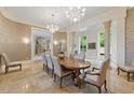 Elegant dining room with chandeliers, decorative columns, and large windows at 32602 Archdale, Chapel Hill, NC 27517