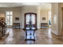 Elegant foyer with stone floors, arched walls, and custom wood doors exudes sophistication at 32602 Archdale, Chapel Hill, NC 27517