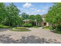 Breathtaking front yard featuring a circular driveway, manicured landscaping, and mature trees at 32602 Archdale, Chapel Hill, NC 27517