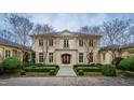Grand facade with stone exterior, arched entryway, and manicured garden beds at 32602 Archdale Dr, Chapel Hill, NC 27517