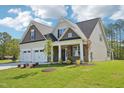 Charming two-story home boasts a manicured lawn, a two car garage, and a welcoming front porch at 35 Hewitt Wds Dr, Clayton, NC 27527