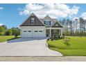 Charming two-story home boasts a manicured lawn, a two car garage, and a welcoming front porch at 35 Hewitt Wds Dr, Clayton, NC 27527