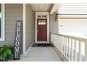 Red front door entryway with a welcome sign and white railing at 4052 Truelove Dr, Apex, NC 27539