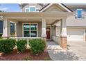 Inviting front porch with red door and brick columns at 4052 Truelove Dr, Apex, NC 27539