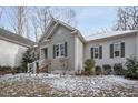 A gray house with white accents and a white front porch in the winter at 4132 Mountainbrook Rd, Apex, NC 27539