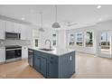 Modern kitchen with white cabinets, blue island, and stainless steel appliances at 5041 Lundy Dr # 101, Raleigh, NC 27606