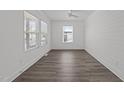Clean, spacious room with three windows providing ample natural light and wood plank flooring at 819 Cumberland St, Raleigh, NC 27610