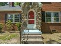 Close-up of the entryway, featuring a stone archway and a bright red screen door at 945 Sycamore St, Rocky Mount, NC 27801