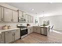 Modern kitchen with gray cabinets, white backsplash, and stainless steel appliances at 100 Summer Mist Ln # 163P, Clayton, NC 27527