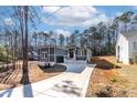 Gray house with stone accents and a long driveway, nestled among trees at 110 Mohave Dr, Louisburg, NC 27549