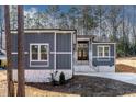 Gray house with stone accents, a long driveway, and surrounding trees at 110 Mohave Dr, Louisburg, NC 27549