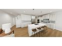 Bright kitchen with white cabinets, stainless steel appliances, and a large center island with seating at 290 Beacon Dr, Pittsboro, NC 27312