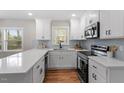 Bright kitchen featuring white cabinets, stainless steel appliances, light backsplash, and quartz countertops at 3305 Victor Pl, Raleigh, NC 27604