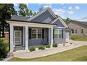 Inviting front porch with classic white columns, gray siding, and manicured landscaping details at 36 Mae Ct, Roxboro, NC 27573