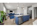 Open concept kitchen with blue island and stainless steel appliances at 36 Mae Ct, Roxboro, NC 27573