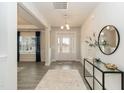 Bright and airy foyer with wood floors, neutral walls, modern console table and a view into the living area at 514 Glenkirk Pl, Garner, NC 27529