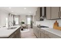 Modern kitchen with gray cabinetry, white subway tile backsplash, and a large island at 613 Emerald Bay Cir, Raleigh, NC 27610