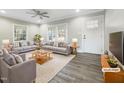 Virtually staged living room with gray sofas, wood coffee table, and hardwood floors at 6307 Tryon Rd, Cary, NC 27518