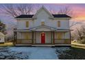 Two-story home with a red front door and wrap-around porch at 801 N Mebane St, Burlington, NC 27217
