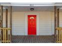 Red front door entrance with sidelights and a porch at 801 N Mebane St, Burlington, NC 27217