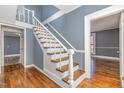 White staircase with wooden railing in a gray-walled hallway at 801 N Mebane St, Burlington, NC 27217