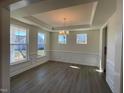 Charming dining room with tray ceiling, decorative chandelier, and large windows, perfect for Gathering meals and entertaining at 85 N Stagecoach Dr, Wendell, NC 27591