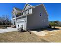 The side and rear exterior view of the home showing the driveway leading to the two-car garage at 85 N Stagecoach Dr, Wendell, NC 27591