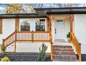 Inviting front porch with wood railing and brick steps at 919 Fiske St, Durham, NC 27703