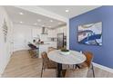 Bright, open kitchen with white cabinets, stainless steel appliances, and breakfast bar at 101 Ailey Brook Way # 100, Wake Forest, NC 27587