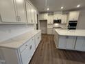 Spacious white kitchen featuring quartz countertops, modern appliances, and hardwood floors at 15 Long Needle Ct # 38, Youngsville, NC 27596