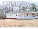 Inviting white home featuring a covered porch and a well-maintained yard at 1696 James Winston Rd, Oxford, NC 27565
