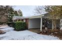 Gray siding with brick accents, covered carport, and a snow-covered yard at 201 Providence Rd, Oxford, NC 27565