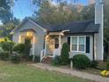 Charming single-story home with a gray exterior, chimney, and manicured front yard at 2213 Stephanie Ln, Clayton, NC 27520