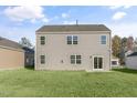 Rear view of a two-story house, showcasing a large backyard at 2557 Summersby Dr, Mebane, NC 27302