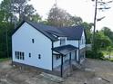 Attractive two-story home featuring white siding, black trim, and a brick-lined, side-entry garage at 301 W College St, Louisburg, NC 27549