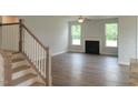 Bright living room features hardwood floors, a cozy fireplace, large windows, and a modern ceiling fan at 71 Priming Way, Angier, NC 27501