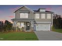 Two-story home with gray siding, stone accents, and a two-car garage at 8701 Maxine St # 43, Willow Springs, NC 27592