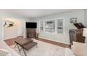 Living room with hardwood floors, fireplace, and large windows offering natural light at 1012 Maple Ave, Apex, NC 27502