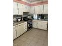 Bright kitchen featuring white cabinets, stainless steel appliances, and tile flooring at 108 Cheney Ct, Garner, NC 27529