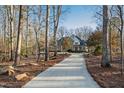 Long driveway leading to a charming home nestled in woods at 1313 Enderbury Dr, Raleigh, NC 27614