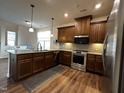 Modern kitchen featuring dark wood cabinets, stainless steel appliances, and light-colored countertops at 133 Walking Path Pl, Hillsborough, NC 27278