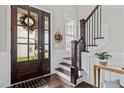 Elegant entryway with dark wood staircase, and decorative wreath at 172 Cotten Dr, Morrisville, NC 27560