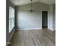 Vaulted ceilings in the dining room with hardwood floors and modern light fixture at 185 N Movado Trl, Kenly, NC 27542
