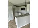 Modern kitchen featuring white cabinets, granite countertops, and stainless steel appliances at 185 N Movado Trl, Kenly, NC 27542