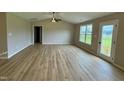 Spacious living room with luxury vinyl plank flooring, ceiling fan and large window at 185 N Movado Trl, Kenly, NC 27542