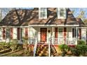 Cozy front porch with white railings and rocking chairs, and a red front door at 1909 Pearces Rd, Zebulon, NC 27597