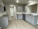 Modern kitchen with gray cabinets, granite countertops, and a tile backsplash at 209 Constellation Ct, Benson, NC 27504