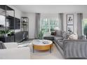 Cozy living room featuring sectional sofa, wood-look floors, and large windows at 2184 Monk Dr, Haw River, NC 27258